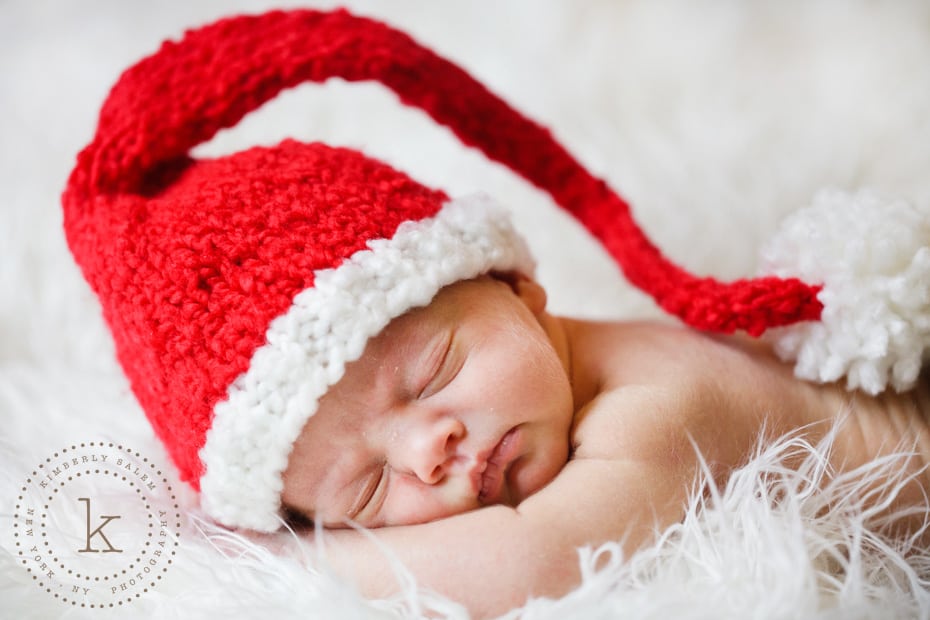 infant wearing long tail Santa hat