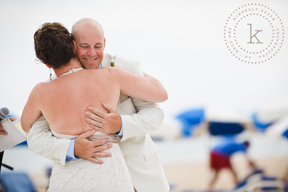 bride and groom embrace - beach wedding