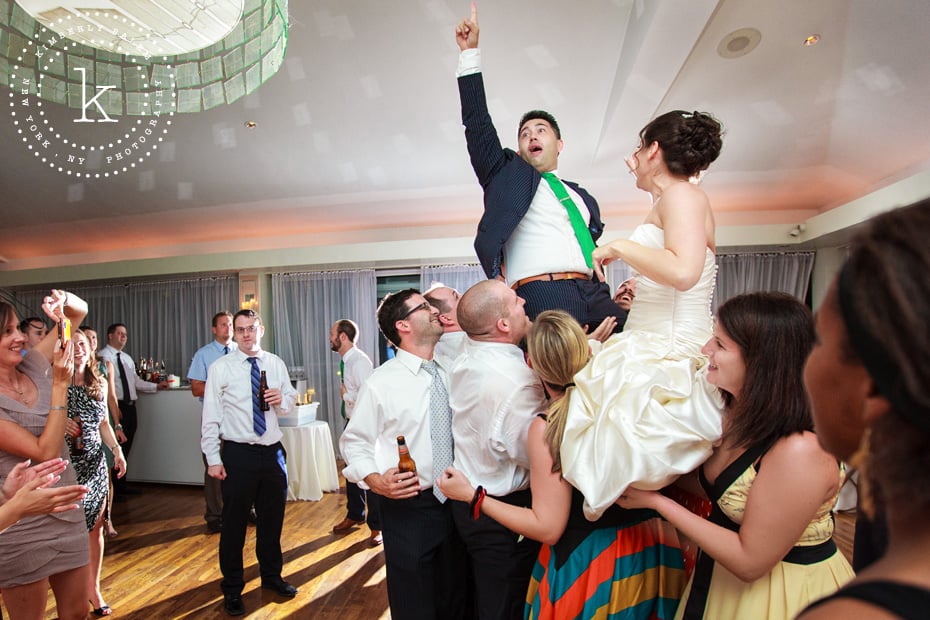 Bride and groom being lifted up at reception