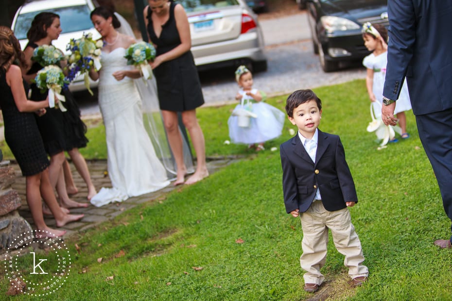 Ring bearer with bride, bridesmaids and flower girls in background