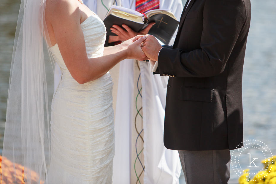 Bride and groom holding hands at ceremony - detail