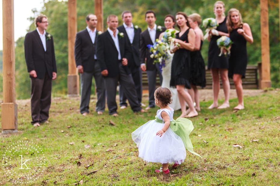 Flower girl looks back at bridal party