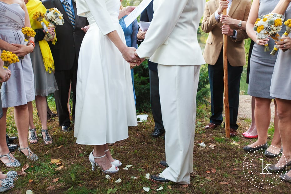 detail of brides holding hands during their wedding ceremony