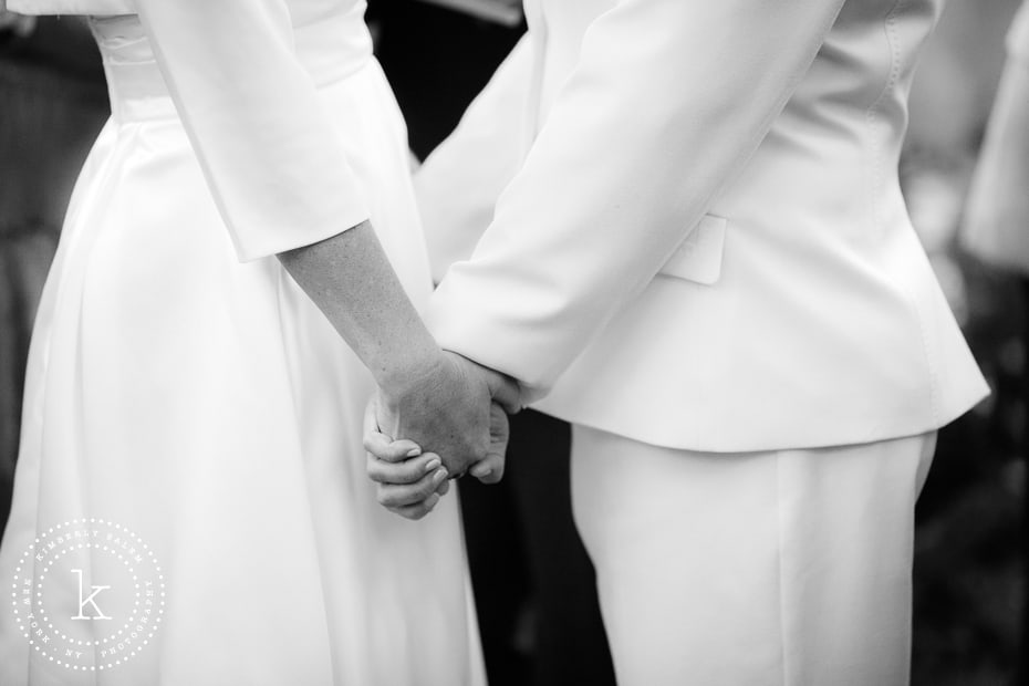 closeup of brides holding hands