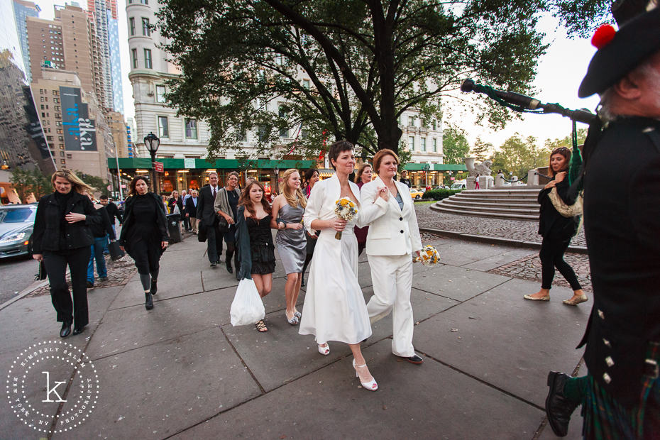 brides walk behind two bagpipers along the streets of Manhattan