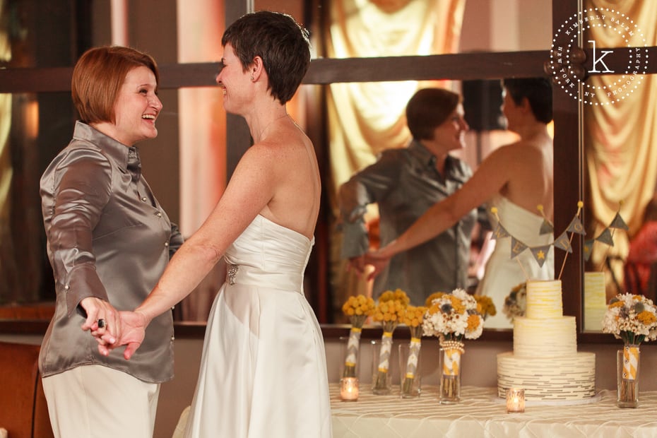 brides with their wedding cake in background