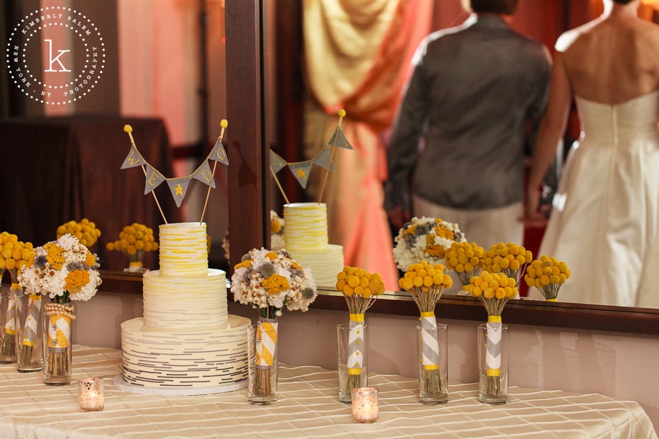 wedding cake with reflection of brides holding hands