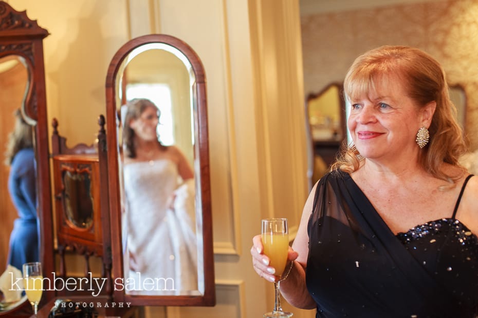 mother of the bride looking on as bride gets ready