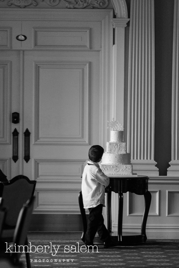 young boy contemplates wedding cake