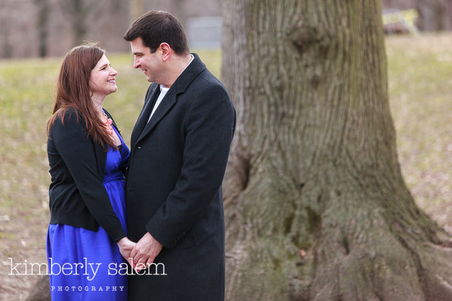 engaged couple in front of tree