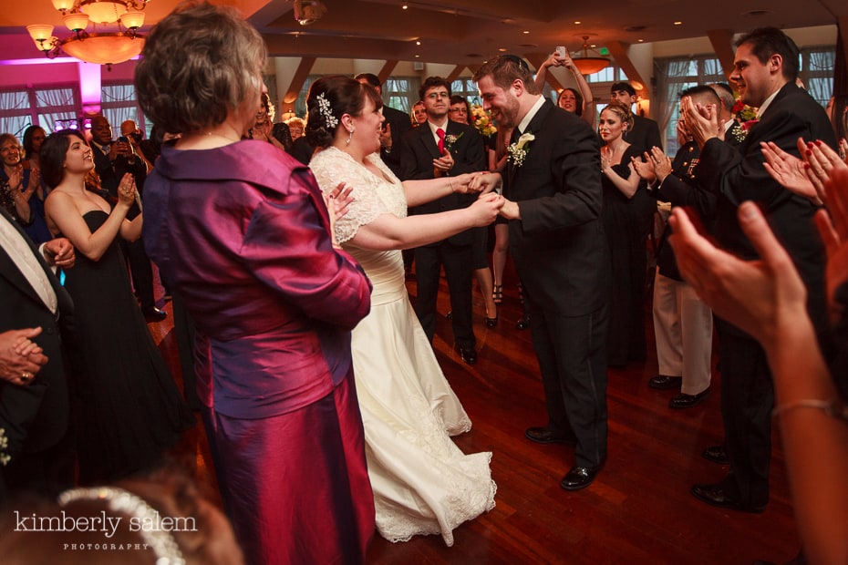 bride and groom first dance surrounded by family during the hora