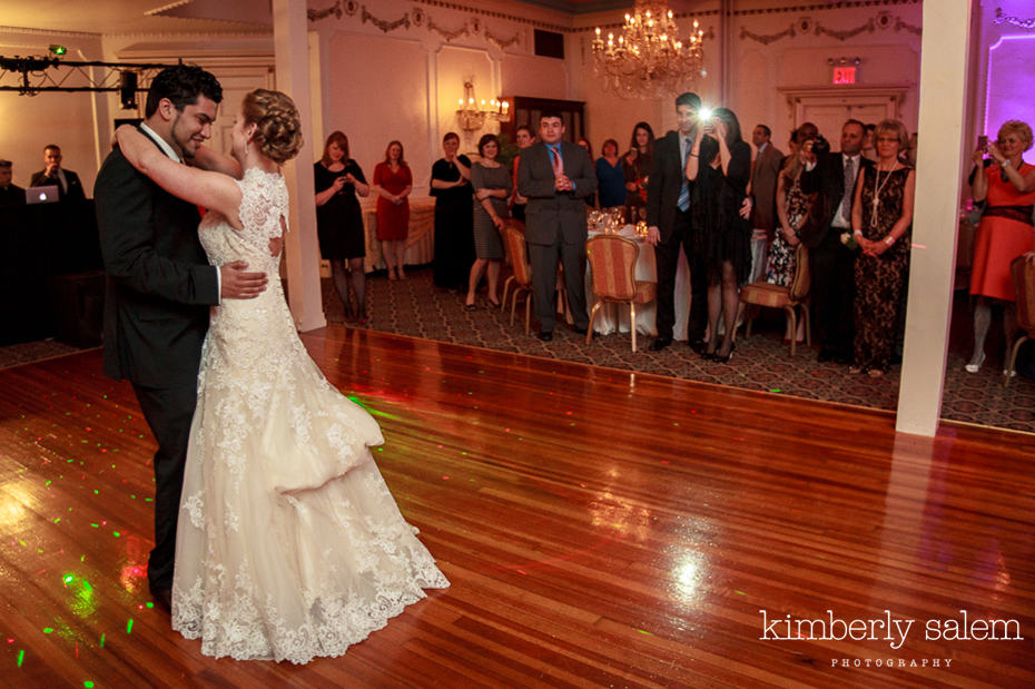 bride and groom dance while guests look on