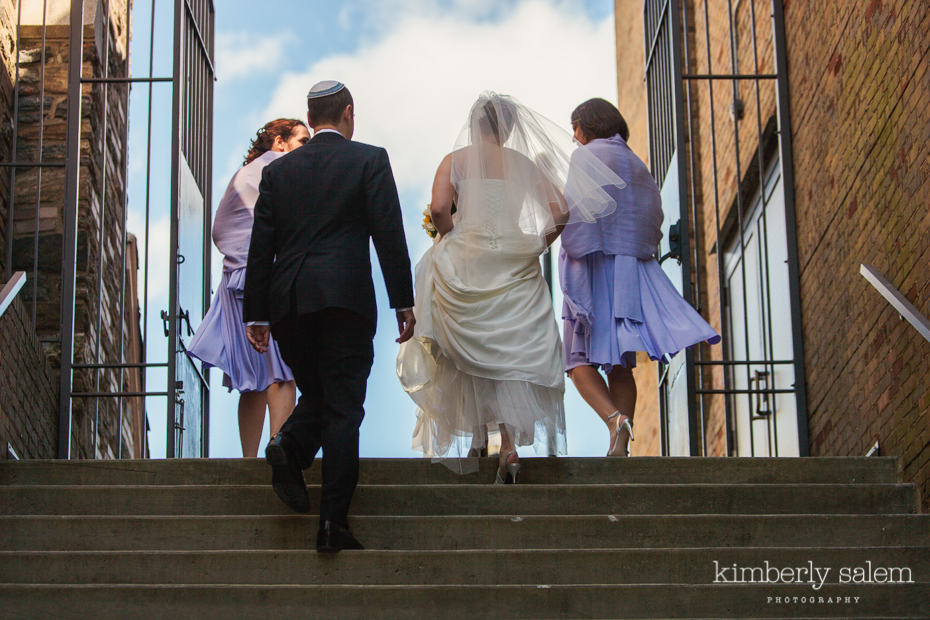 bride, groom and bridesmaids walking upstairs