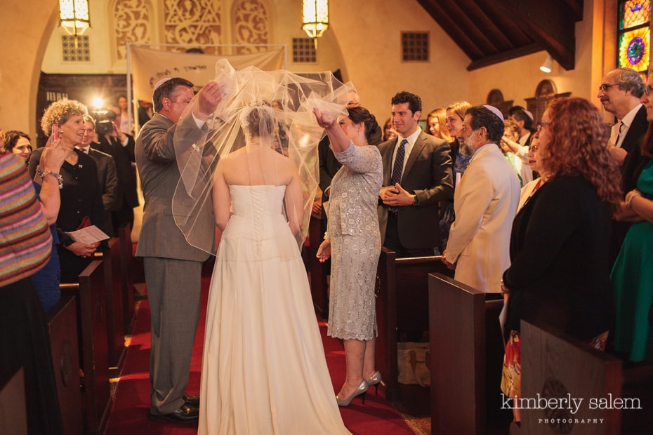 bride's parents pull back her veil