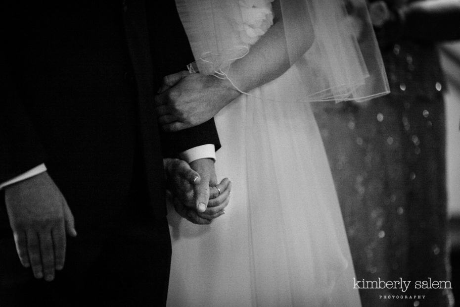 bride holds onto groom's hand