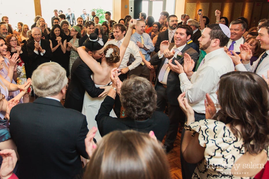 bride and groom surrounded by guests on the dance floor