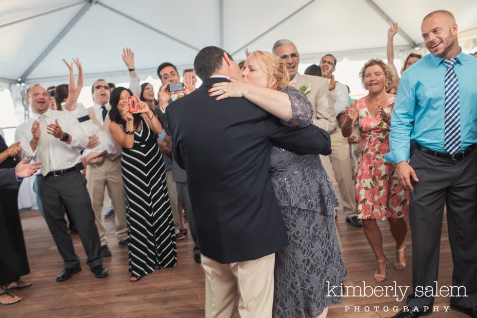 bride and groom kiss during first dance with guests looking on