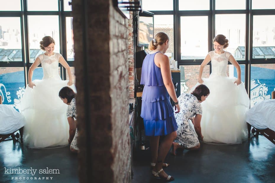 Bride getting ready - maid of honor helping her dress