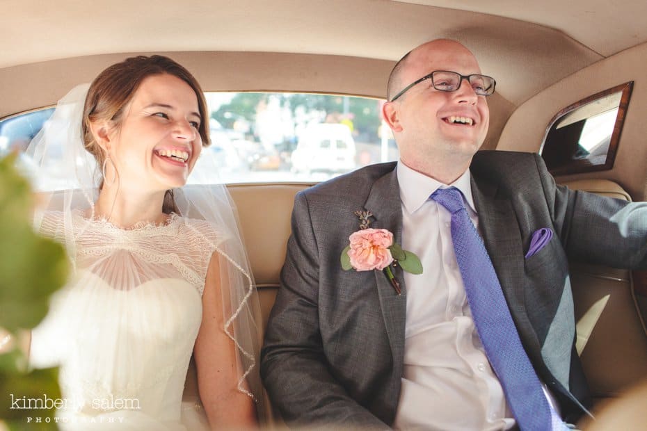 Bride and groom laugh inside Rolls Royce