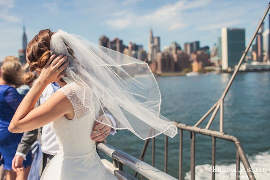 Bride's veil blows in the wind on the East River Ferry