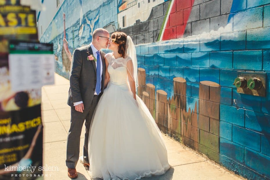 Bride and groom kiss in front of a painted mural in Williamsburg, Brooklyn