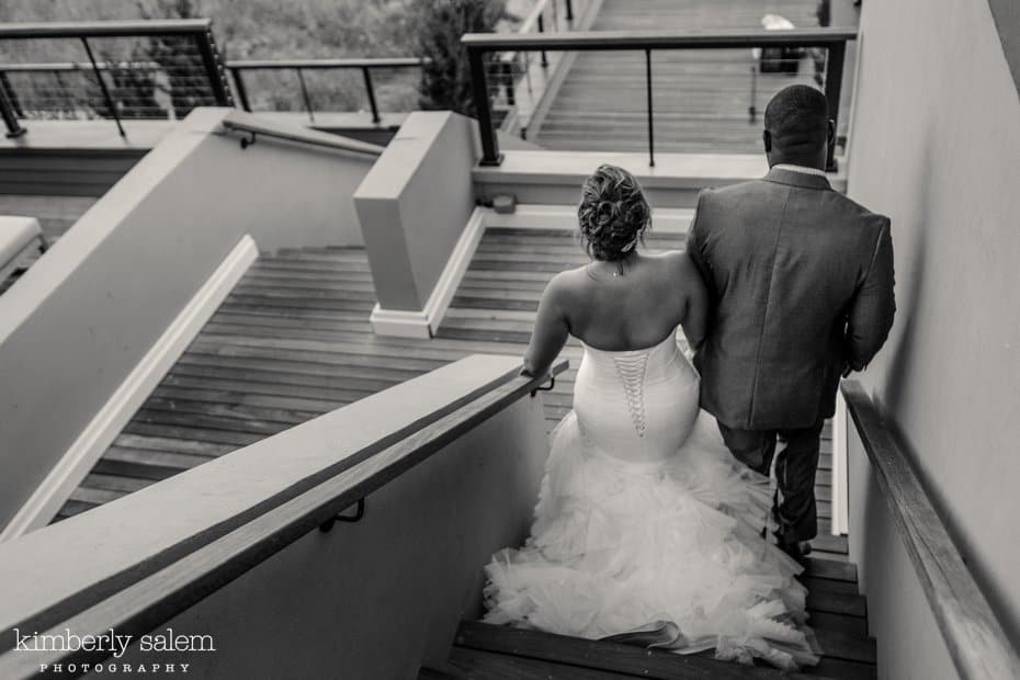 bride and groom walk down the winding stairs at Gurney's Inn